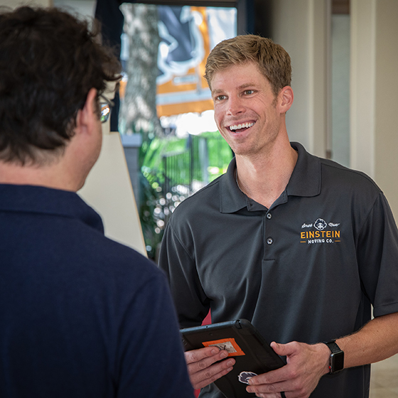 Cameron Brown smiles while talking with a customer. The customers back is to the camera