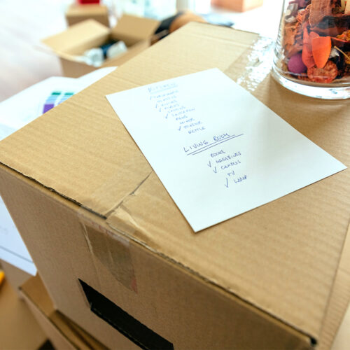 A cardboard box with a moving checklist on top of it.