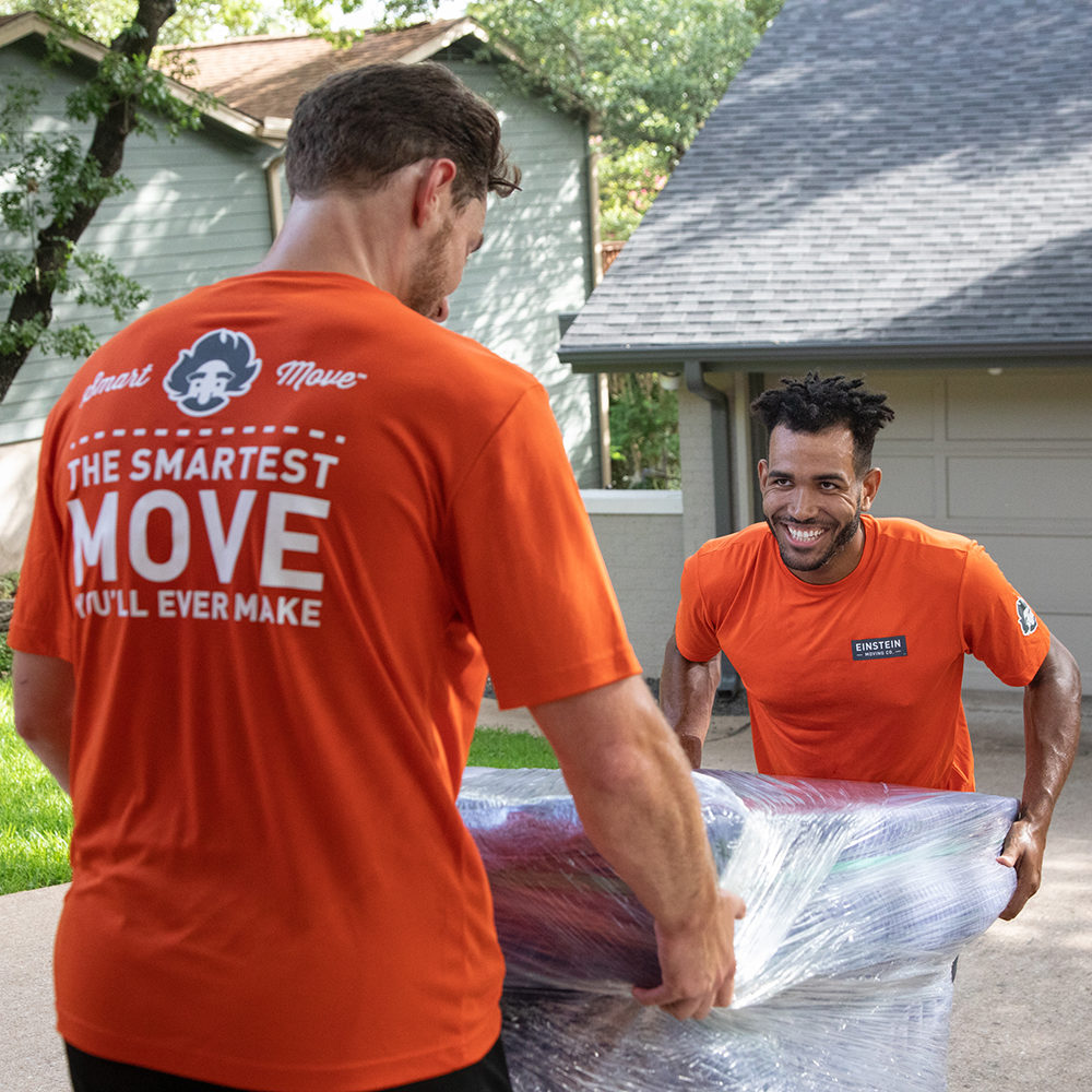 Two Einstein movers load a couch into a moving truck