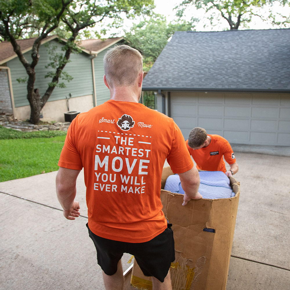 Two Einstein movers haul a large box into a moving truck