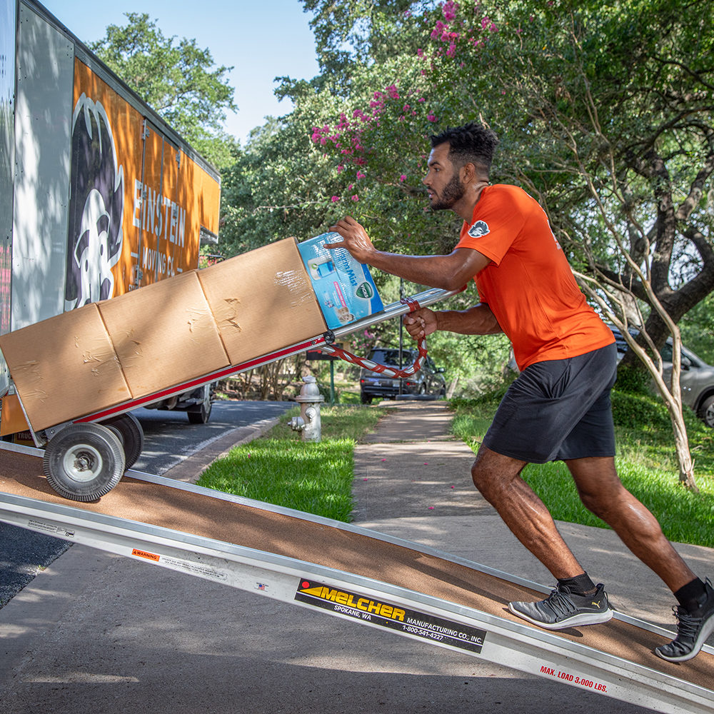 An Einstein mover loads a stack of boxes into a moving truck