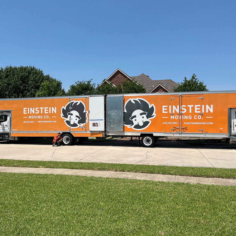 The back ends of two Einstein moving trucks touch in McKinney