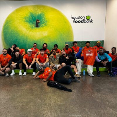 Our Einstein movers posing as a group in front of the Houston Food Bank decorated wall.