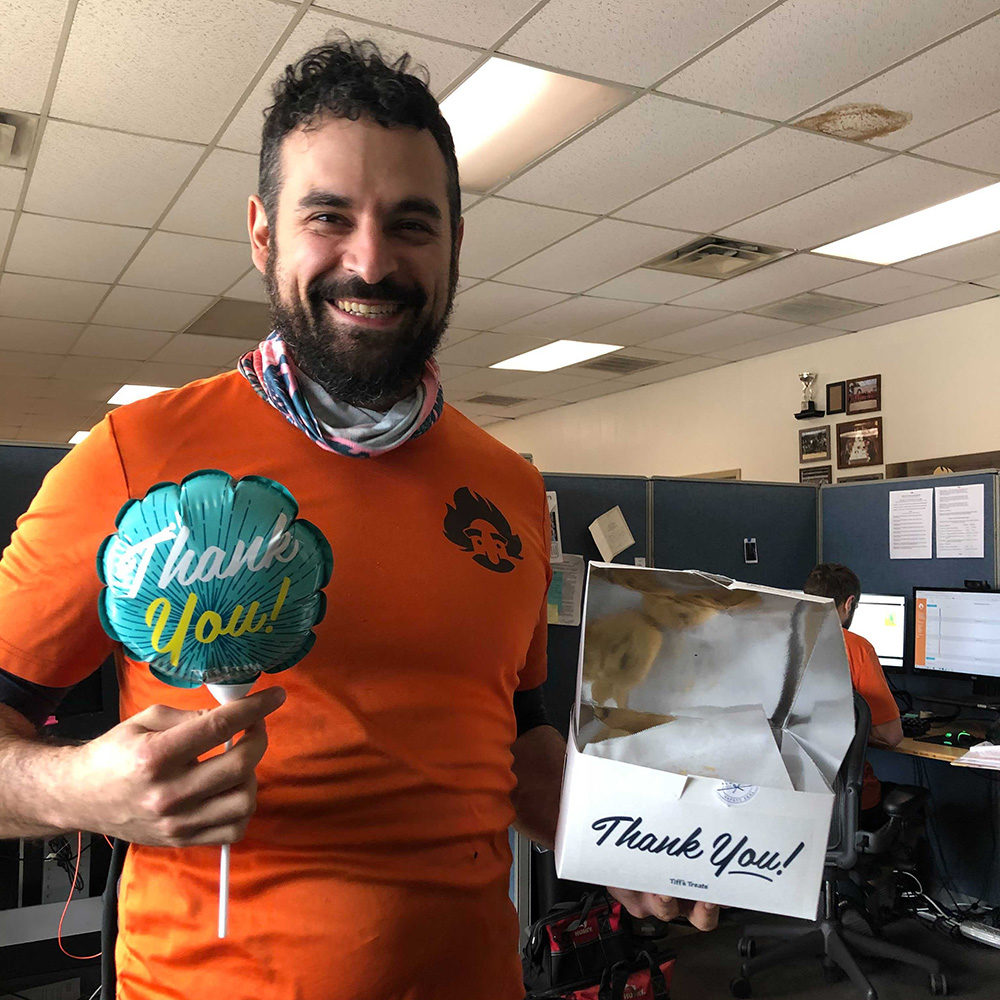 South Austin Manager, Jespah Lara, holds a balloon and gift box that both say Thank You