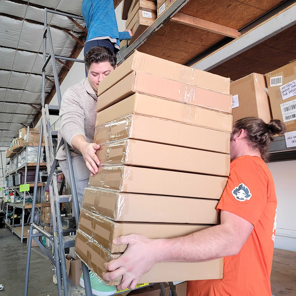 Movers helping stock a warehouse.