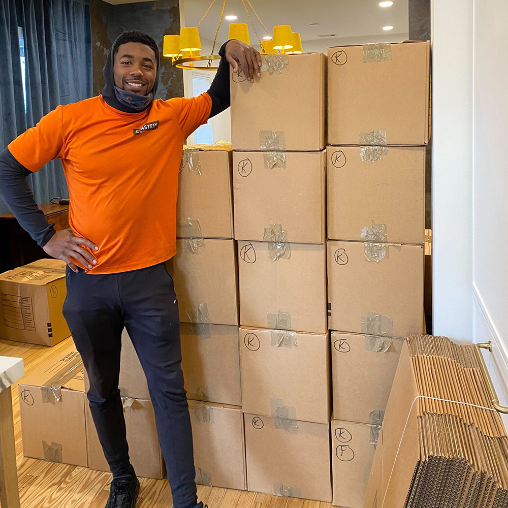 Man smiling for camera after finishing packing up boxes.