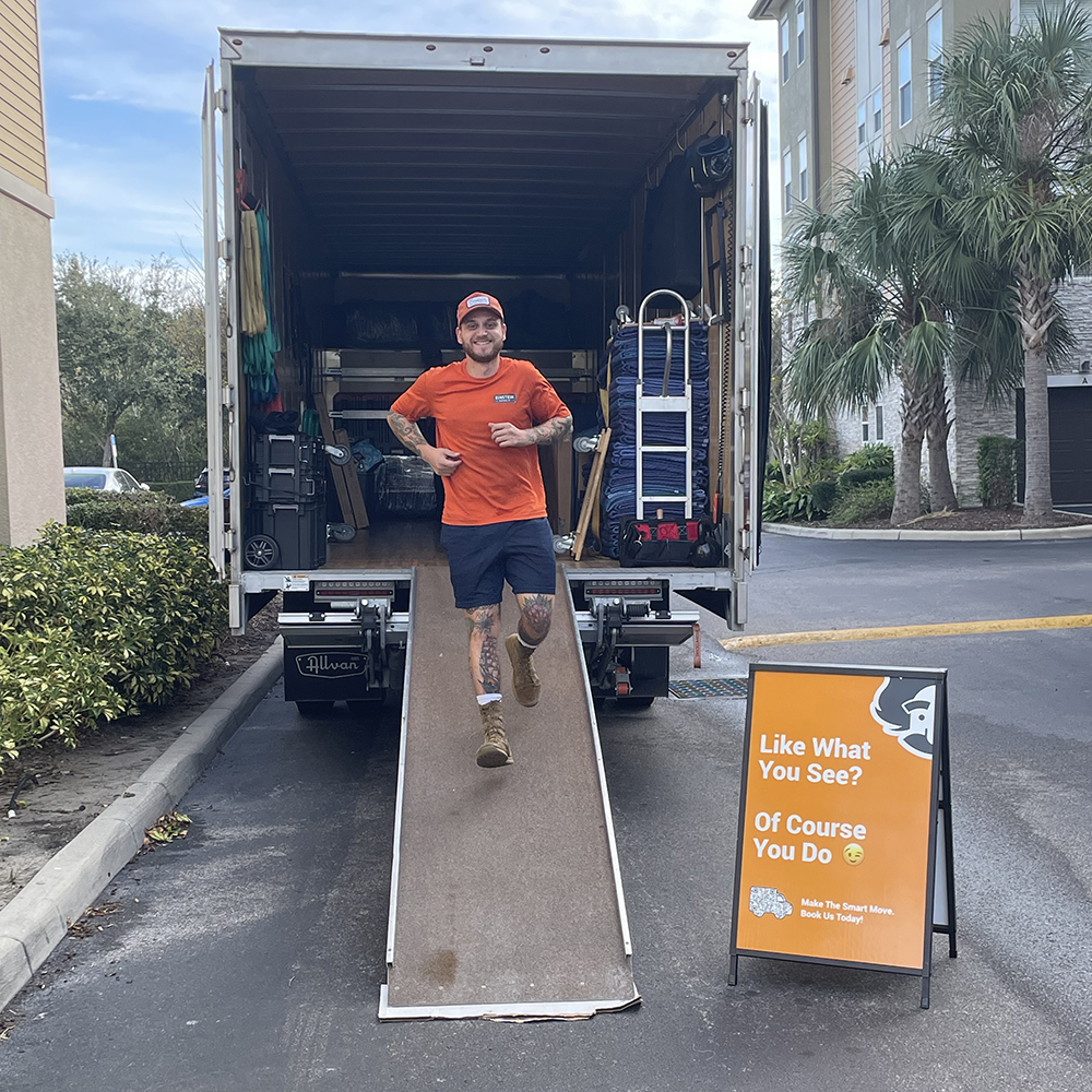 Man steps out of a moving truck, ready to pack up more furniture.