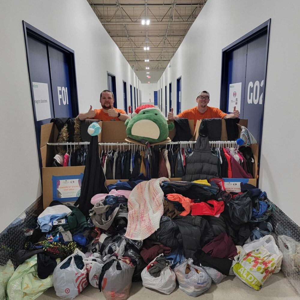 Movers in front of 483 items collected in the Fort Worth Coat Drive.